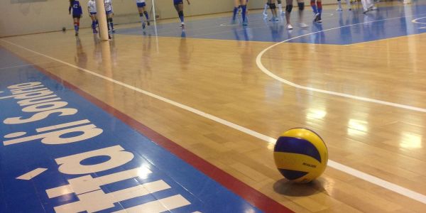 pallone in primo piano con squadra sullo sfondo